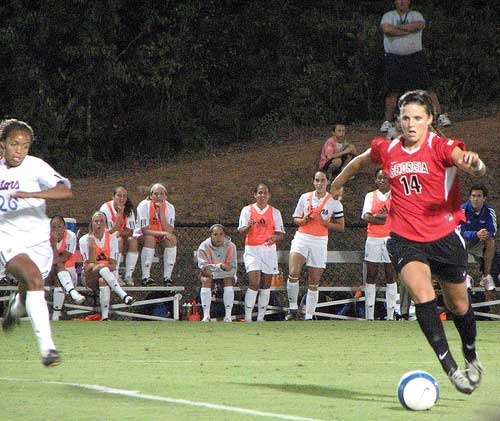 Lady Bulldog player sprints with soccer ball 