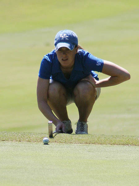  UK Women's golfer lines up putt 
