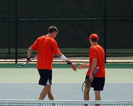 Auburn tennis doubles partners shake hands after winning point